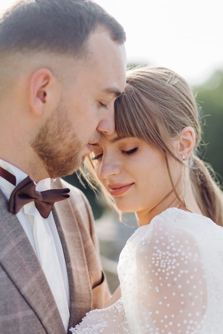 Marié posant son front contre celui de la mariée